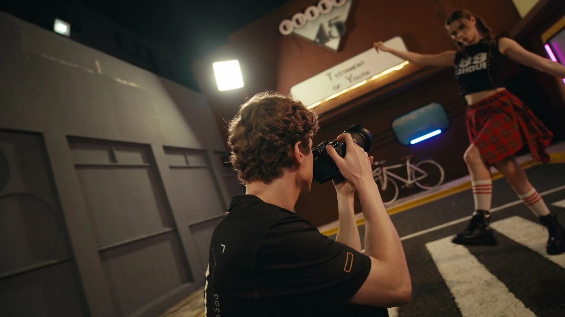 A commercial photographer capturing a model on a working set