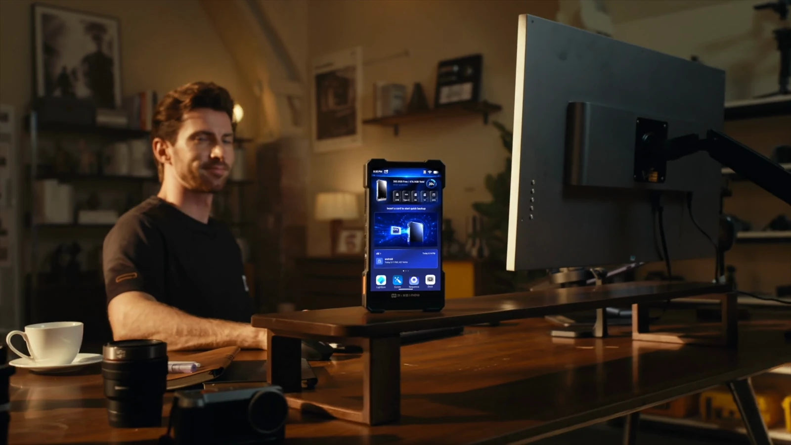 PixelMob standing beside a desktop monitor in a creator’s editing workspace