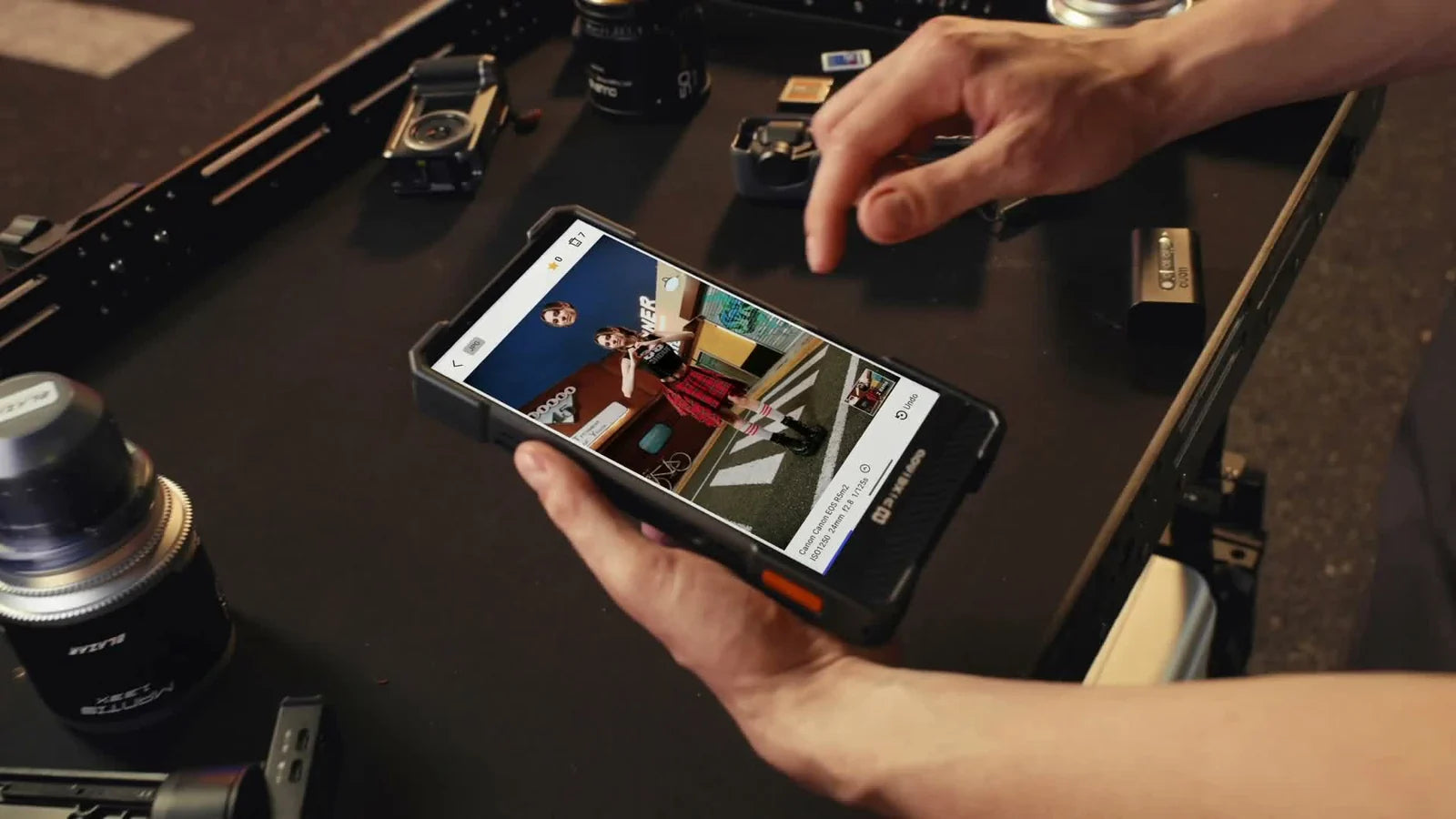 Hands operating a working PixelMob touchscreen to review photographs